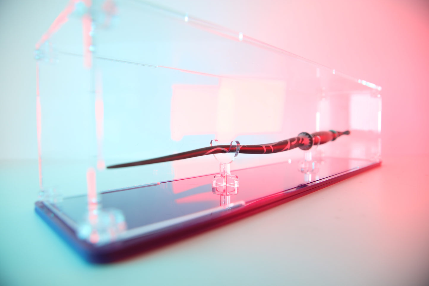 Clear acrylic wand display case with coloured base.