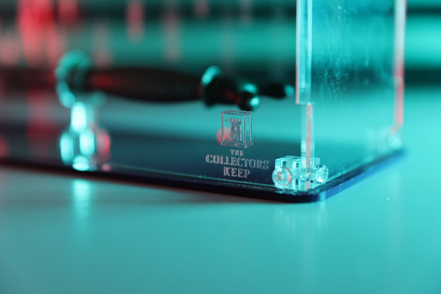 Clear acrylic display case with 'The Collector's Keep' logo on the front.