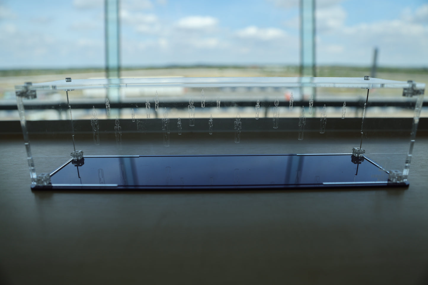Clear acrylic wand display case with coloured base and candle engraving on the back.