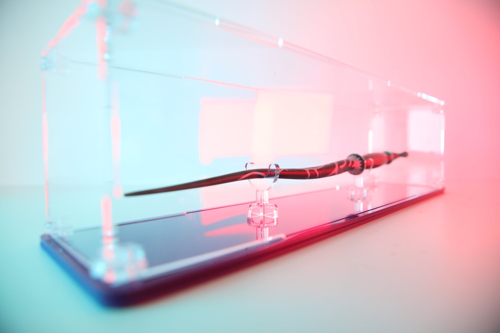Clear acrylic wand display case with coloured base.