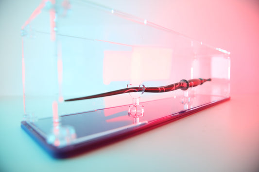 Clear acrylic wand display case with coloured base.