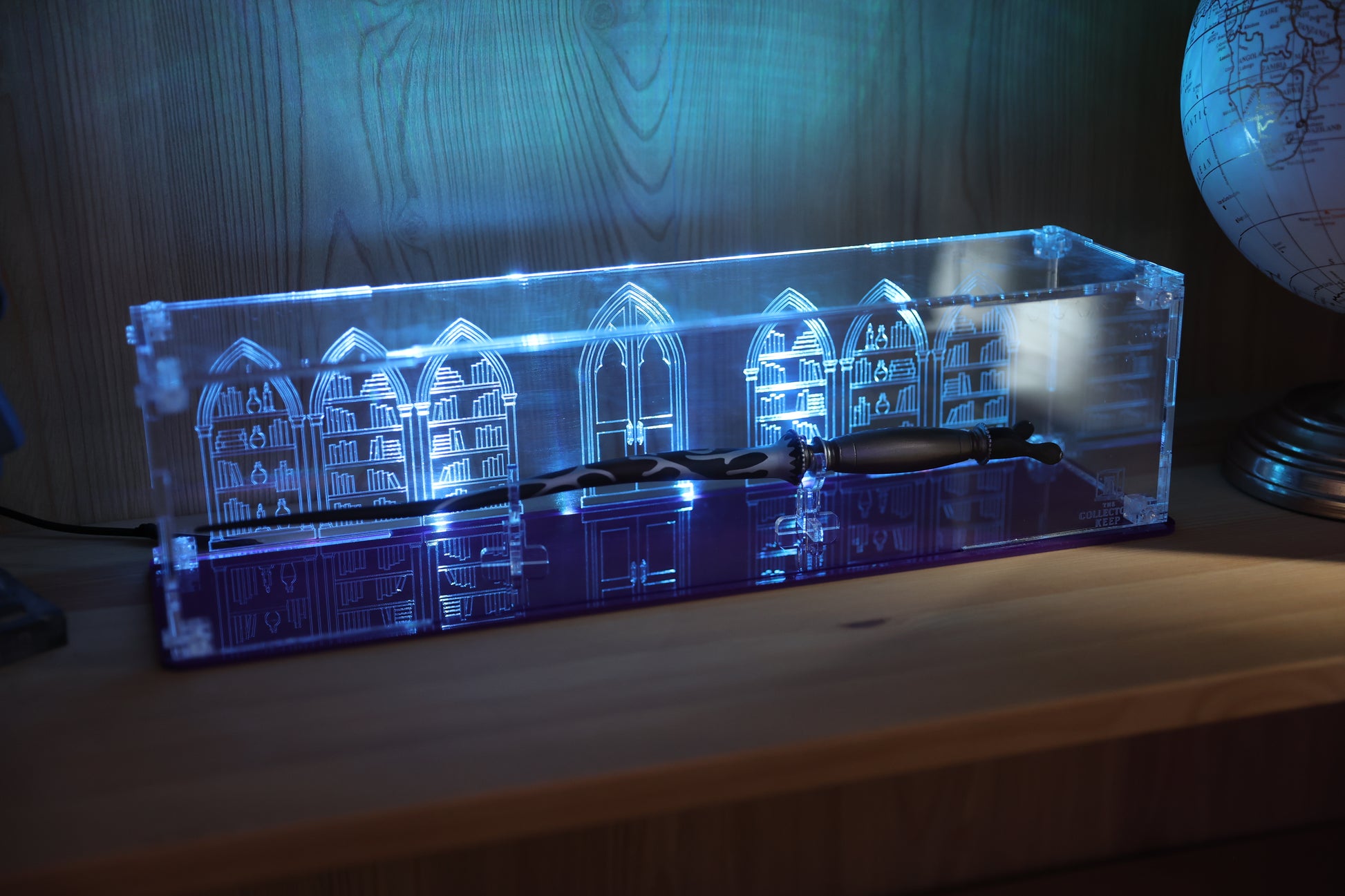 Clear acrylic wand display case with coloured base and library engraving on the back.