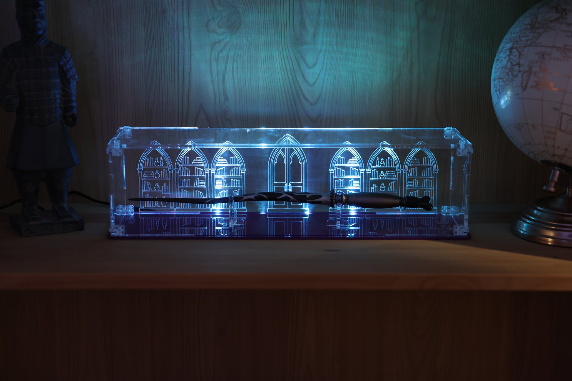 Clear acrylic wand display case with coloured base and library engraving on the back.