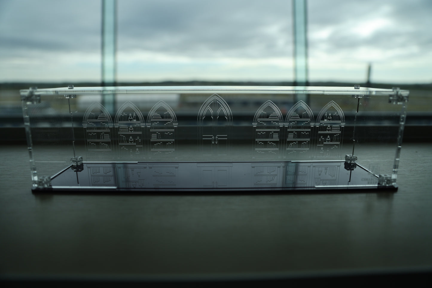 Clear acrylic wand display case with coloured base and library engraving on the back.