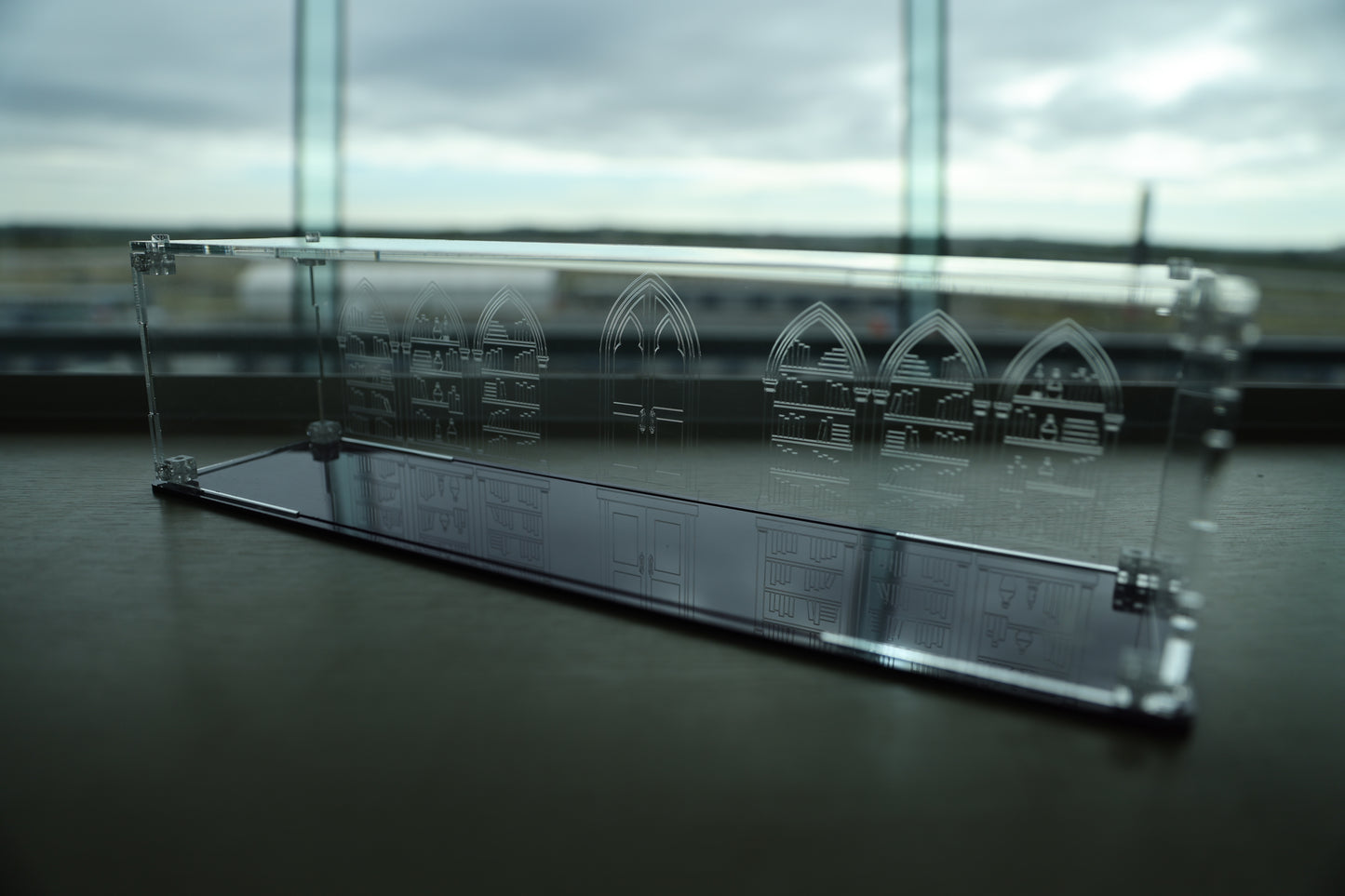 Clear acrylic wand display case with coloured base and library engraving on the back.