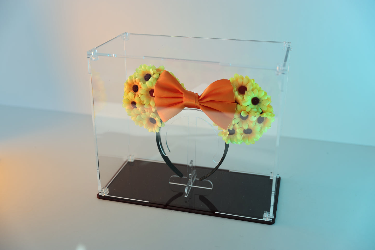 Mickey ears headband in a clear display case with coloured base.