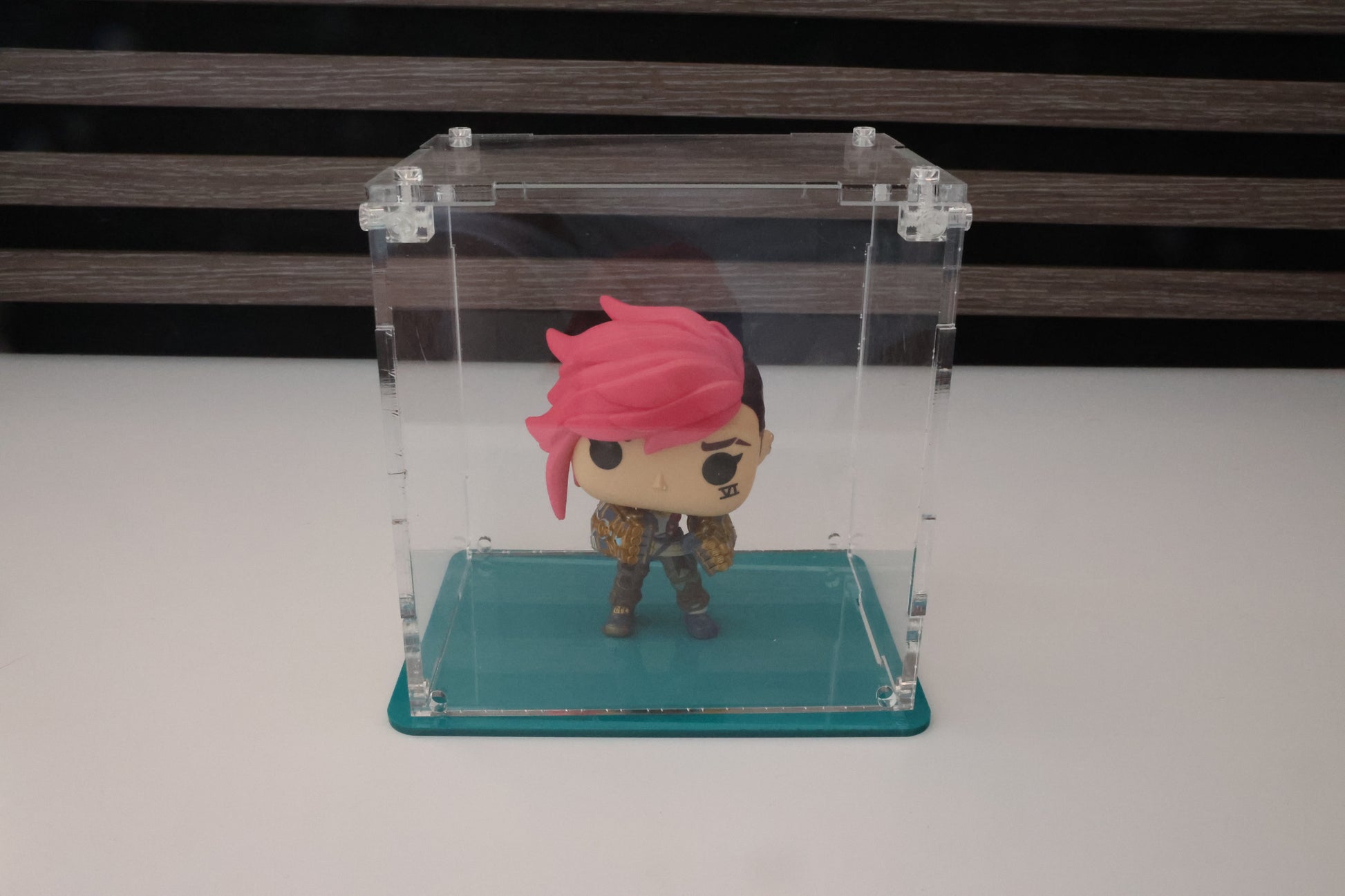 Funko Pop! vinyl figure in a clear acrylic display case with a coloured base.