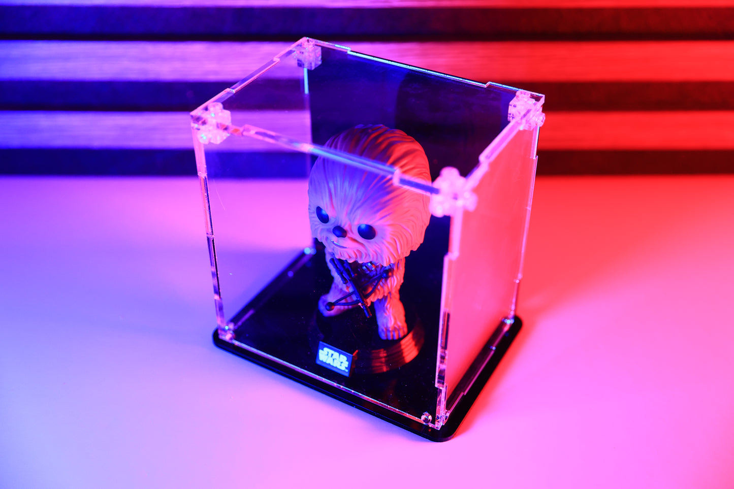 Funko Pop! vinyl figure in a clear acrylic display case with a coloured back and base.
