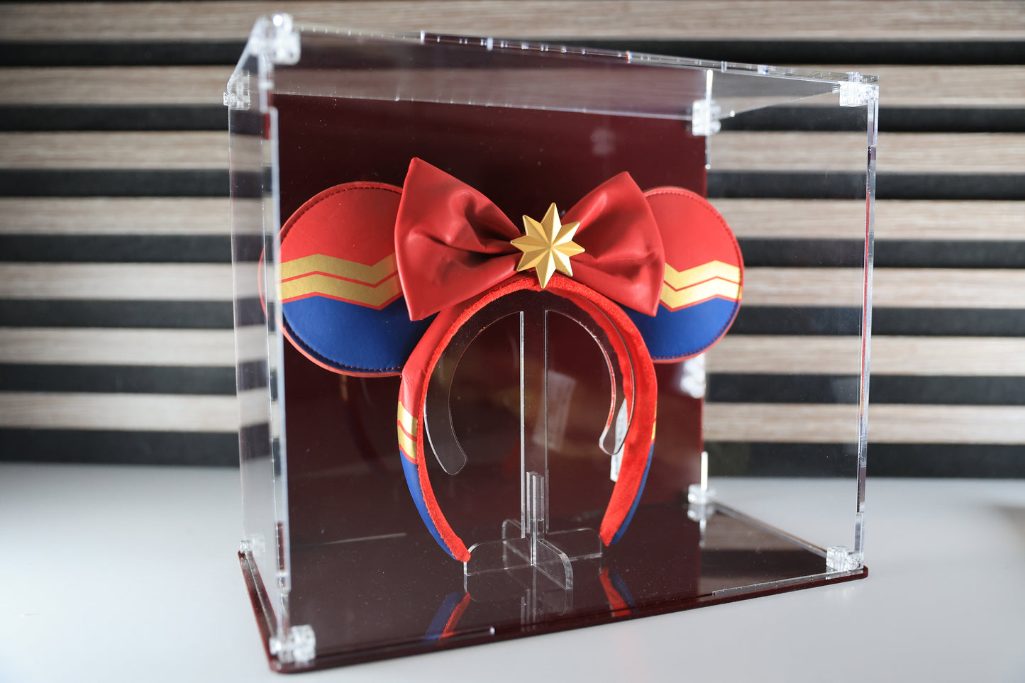 Mickey ears headband in a clear display case with coloured base and coloured back.