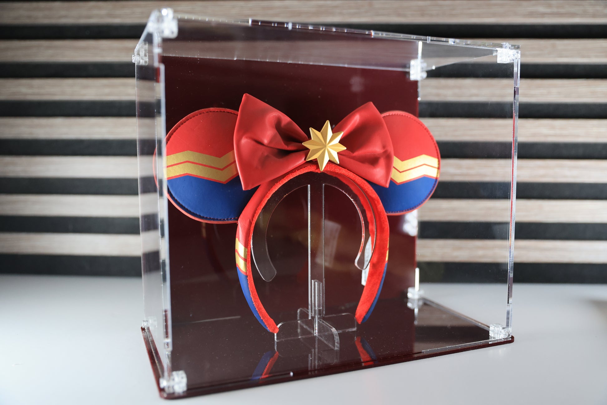 Mickey ears headband in a clear display case with coloured base and coloured back.